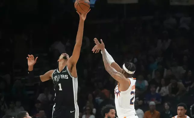 San Antonio Spurs forward Victor Wembanyama (1) blocks a 3-point shot by Phoenix Suns guard Jordan Goodwin, right, during a preseason NBA basketball game, Saturday, Oct. 10, 2026, in Phoenix. (AP Photo/Ross D. Franklin)