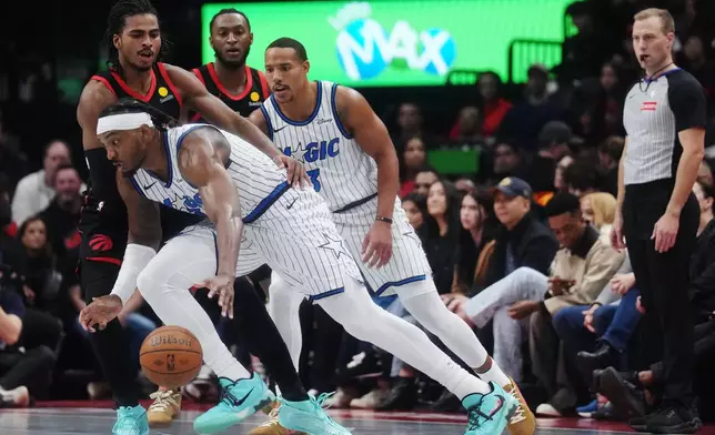 Orlando Magic's Wendell Carter Jr., front, drives past Toronto Raptors' Collin Murray-Boyles, top left, during the first half of an NBA Cup basketball game in Toronto, Friday, Oct. 30, 2026. (Nathan Denette/The Canadian Press via AP)