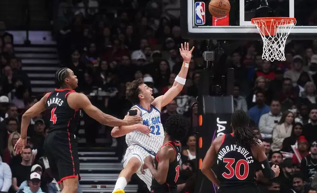Orlando Magic's Franz Wagner (22) shoots past Toronto Raptors' Scottie Barnes (4) during the first half of an NBA Cup basketball game in Toronto, Friday, Oct. 30, 2026. (Nathan Denette/The Canadian Press via AP)