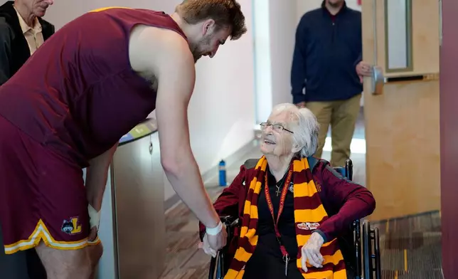 FILE - Loyola University basketball player, Tom Welch, shakes hands with Sister Jean Dolores Schmidt, the team's official chaplain, before attending practice on Monday, Jan. 23, 2023, in Chicago. (AP Photo/Jessie Wardarski)