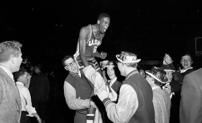 FILE - University of San Francisco basketball player Bill Russell is carried from the floor of the Municipal Auditorium in Kansas City, Mo., by students celebrating a win over La Salle for the NCAA basketball championship, March 19, 1955. (AP Photo/Bill Streator, File)