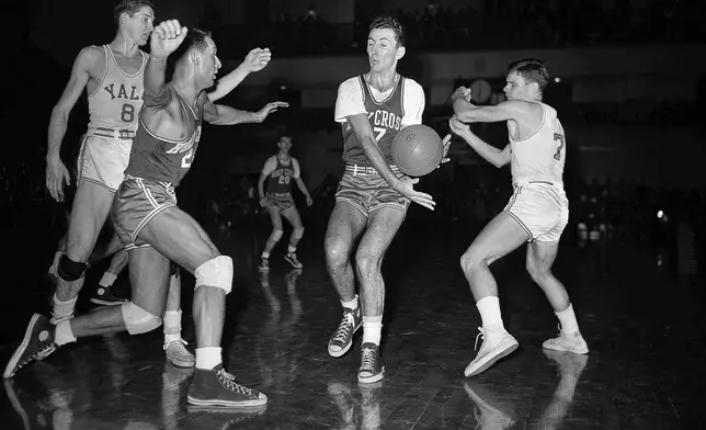 FILE - Bob Cousy, Holy Cross forward, second from right, intercepts a pass intended for Tony Lavelli, (8) of Yale, left, in first period of an NCAA college basketball game Feb. 19, 1949, in New Haven, Conn. Rob McMullen of Holy Cross, left, comes in on the play. Art Fizgerald, (7) of Yale is at right. (AP Photo/File)
