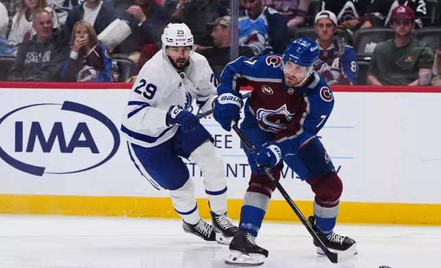 Colorado Avalanche defenseman Devon Toews, right, collects the puck as Toronto Maple Leafs center Bo Groulx, left, defends in the second period of an NHL hockey game Saturday, Oct. 10, 2026, in Denver. (AP Photo/David Zalubowski)
