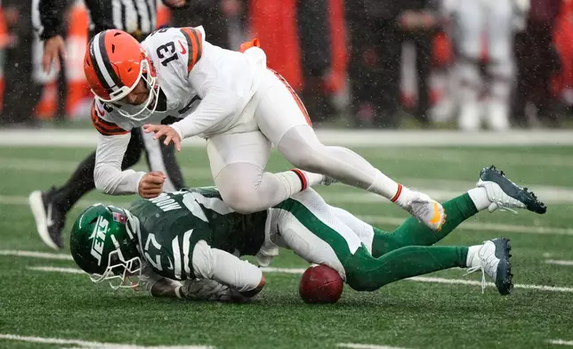 Cleveland Browns punter Corey Bojorquez (13) fights for a fumbled snap with New York Jets safety Malachi Moore (27) during the second half of an NFL football game, Sunday, Oct. 11, 2026, in East Rutherford, N.J. (AP Photo/Seth Wenig)
