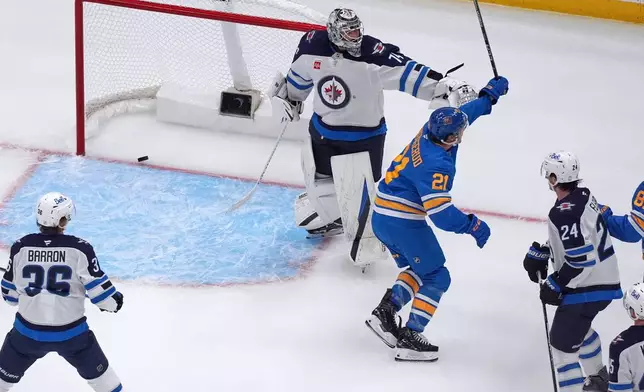 St. Louis Blues' Jimmy Snuggerud (21) celebrates after scoring past Winnipeg Jets goaltender Stuart Skinner (74) during the first period of an NHL hockey game Tuesday, Oct. 20, 2026, in St. Louis. (AP Photo/Jeff Roberson)