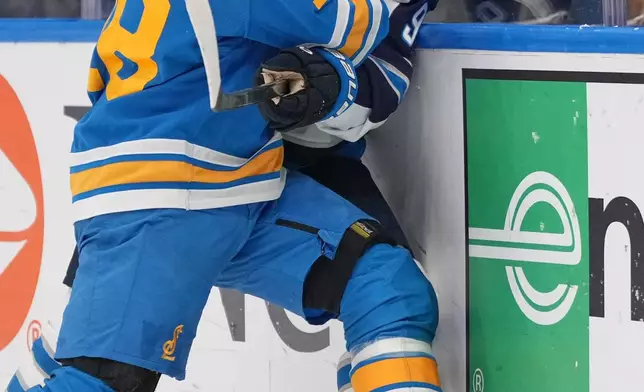 St. Louis Blues' Robert Thomas (18) and Winnipeg Jets' Cole Perfetti (91) battle for a loose puck along the boards during the first period of an NHL hockey game Tuesday, Oct. 20, 2026, in St. Louis. (AP Photo/Jeff Roberson)