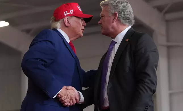 President Donald Trump shakes hands with Georgia U.S. Senate candidate Rep. Mike Collins, R-Ga., at a campaign rally at Dalton Municipal Airport, Friday, Oct. 16, 2026, in Dalton Ga. (AP Photo/Mark Schiefelbein)