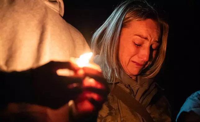 Dara Crawford cries during a candlelight vigil at Drake Park following a deadly shooting at Silver Rail Elementary School in Bend, Ore. on Thursday, Oct. 15, 2026. (Eli Imadali/Oregon Public Broadcasting via AP)