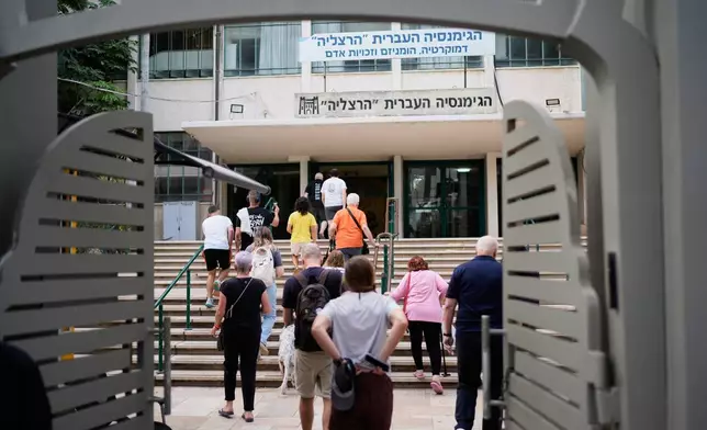 Voters arrive at a school used as a polling station during Israel's general election in Tel Aviv, Israel, Tuesday, Oct. 27, 2026. (AP Photo/David Goldman)