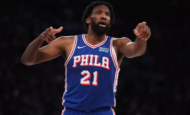 Philadelphia 76ers center Joel Embiid gestures towards teammate forward LeBron James during the second half of an NBA basketball game against the New York Knicks Tuesday, Oct. 20, 2026, in New York. (AP Photo/Frank Franklin II)