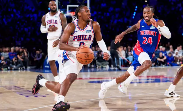 Philadelphia 76ers' Tyrese Maxey center takes the pass from LeBron James, left, as he drives to the basket against Detroit Pistons' Daniss Jenkins (24) during the second half of an NBA basketball game, Sunday, Oct. 25, 2026, in Philadelphia. (AP Photo/Chris Szagola)