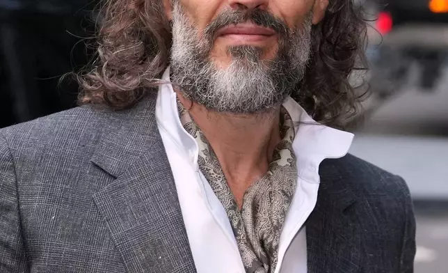 Comedian and actor Russell Brand arrives at Southwark Crown Court where he is charged with counts of rape and sexual assault against six women, which he has denied, in London, Monday, Oct. 12, 2026.(AP Photo/Kin Cheung)