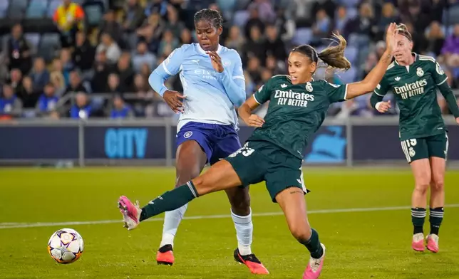 Manchester City's Khadija Shaw, left, challenges for the ball with Real Madrid's Maelle Lakrar during the Women's Champions League opening phase soccer match between Manchester City and Real Madrid in Manchester, England, Thursday, Oct. 1, 2026. (AP Photo/Dave Thompson)