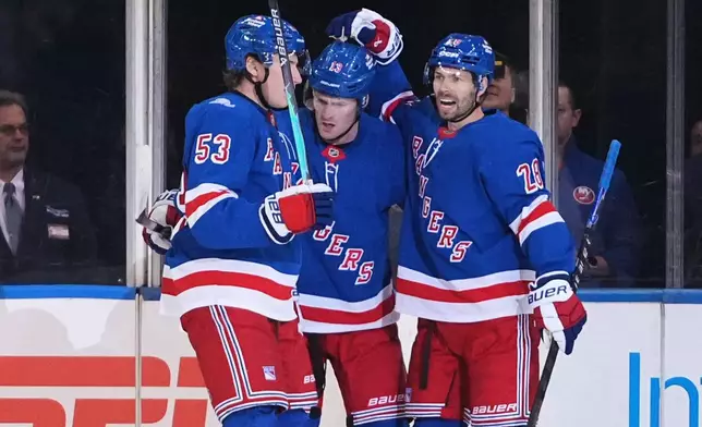 New York Rangers' Oliver Bjorkstrand (28) celebrates with teammates Alexis Lafrenière (13) and Cole Beaudoin (53) after scoring a goal during the first period of an NHL hockey game against the New York Islanders Tuesday, Oct. 6, 2026, in New York. (AP Photo/Frank Franklin II)