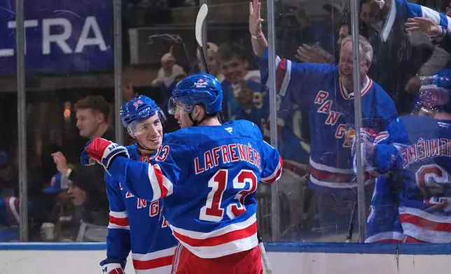 New York Rangers' Alexis Lafrenière (13) celebrates with teammate Gabe Perreault (94) after scoring a goal during the second period of an NHL hockey game against the New York Islanders Tuesday, Oct. 6, 2026, in New York. (AP Photo/Frank Franklin II)