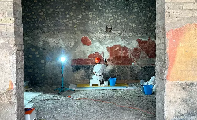 In this undated handout photo provided on Tuesday, Oct. 20, 2026, by the Pompeii Archaeological Park, restorers work inside the House of Marcus Fabius Rufus in Pompeii, near Naples, Italy. (Silvia Vacca/ Pompeii Archaeological Park via AP)