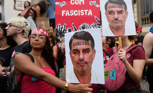 Students hold defaced images of presidential candidate Sen. Flavio Bolsonaro as they march to defend public education and support Brazilian President Luiz Inacio Lula da Silva, who is running for a fourth term, ahead of the presidential runoff election in Rio de Janeiro, Wednesday, Oct. 7, 2026. (AP Photo/Silvia Izquierdo)