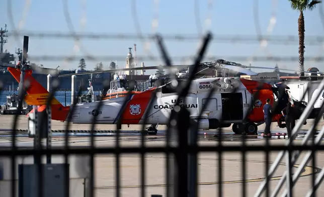 Coast Guardsmen work on a helicopter at Coast Guard Station San Diego on Friday, Oct. 16, 2026. (AP Photo/Denis Poroy)