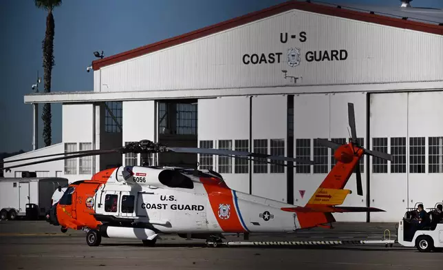 Coast Guardsmen work on a helicopter at Coast Guard Station San Diego on Friday, Oct. 16, 2026. (AP Photo/Denis Poroy)