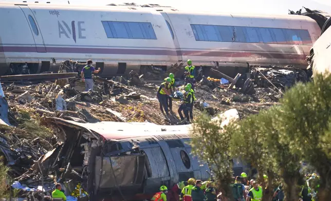 Emergency services attend to the victims at the scene of a collision between two trains in Urda, Spain, on Wednesday, Oct. 28, 2026. (AP Photo/Manu Fernandez)