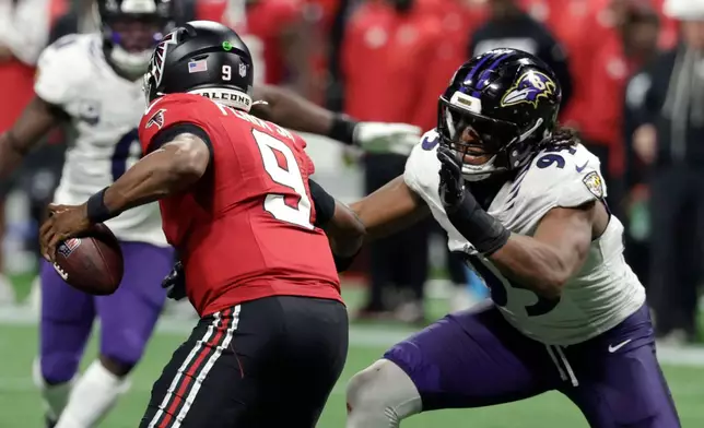 Baltimore Ravens linebacker Tavius Robinson (95) pressures Atlanta Falcons quarterback Michael Penix Jr. (9) during the second half of an NFL football game, Sunday, Oct. 11, 2026, in Atlanta. (AP Photo/Erik S. Lesser)