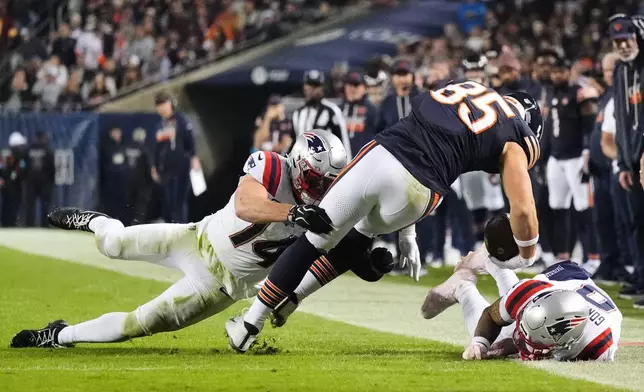 Chicago Bears tight end Cole Kmet (85) catches a pass and is tackled by New England Patriots' Robert Spillane (14) and Christian Gonzalez, right, during the second half of an NFL football game in Chicago, Thursday, Oct. 22, 2026. (AP Photo/Nam Y. Huh)