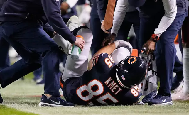 Chicago Bears tight end Cole Kmet (85) holds his right leg after suffering an injury on a pass play during the second half of an NFL football game against the New England Patriots in Chicago, Thursday, Oct. 22, 2026. (AP Photo/Nam Y. Huh)