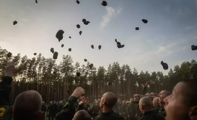 FILE - Newly recruited soldiers toss their hats as they celebrate the end of their training at a military base close to Kyiv, Ukraine, Monday, Sept. 25, 2023. (AP Photo/Efrem Lukatsky, File)