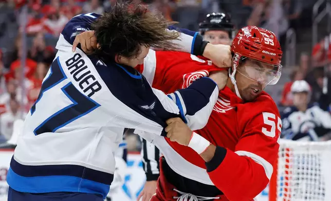Winnipeg Jets defenseman Tyrel Bauer, left, and Detroit Red Wings right wing Keegan Kolesar (55) fight during the first period of an NHL hockey game Sunday, Oct. 4, 2026, in Detroit. (AP Photo/Duane Burleson)