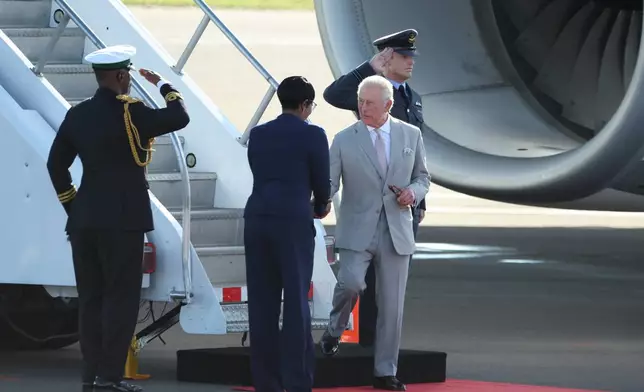 Britain's King Charles III is welcomed as he deplanes at the Lynden Pindling Airport in Nassau, Bahamas, Tuesday, Oct. 27, 2026. (AP Photo/Tim Aylen)