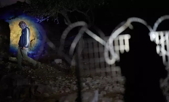 A member of the Palestinian-Bedouin Kaabneh family uses a flashlight after spotting Israeli settlers throwing stones at her house on the outskirts of the West Bank town of Taybeh, Thursday, Oct. 1, 2026. (AP Photo/Leo Correa)