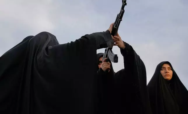 Volunteers train how to handle a Kalashnikov-style assault rifle while attending a military training course at a camp set up in Imam Hussein Square in Tehran, Sunday, Oct. 4, 2026. (AP Photo/Vahid Salemi)