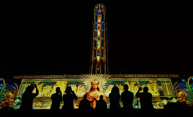 People view artwork projected onto the 217-foot-tall tower and north wall at the National World War I Museum and Memorial Saturday, Oct. 3, 2026, in Kansas City, Mo. (AP Photo/Charlie Riedel)