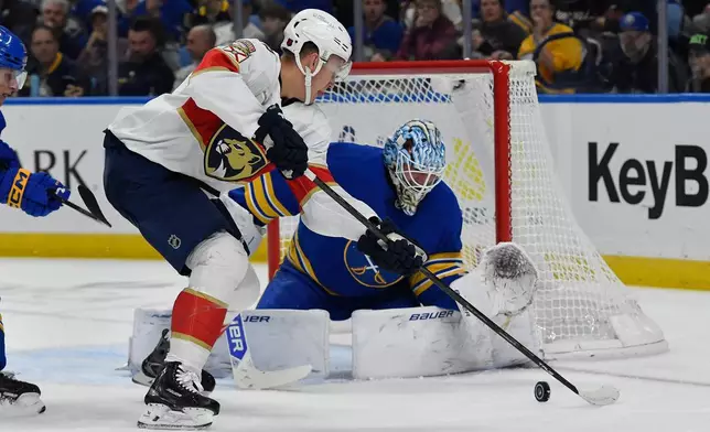 Florida Panthers left wing Brady Tkachuk, left, skates the puck in on Buffalo Sabres goalie Ukko-Pekka Luukkonen during the second period of an NHL hockey game Monday, Oct. 12, 2026, in Buffalo, N.Y. (AP Photo/Adrian Kraus)