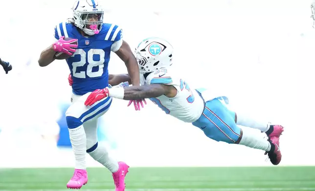 Indianapolis Colts running back Jonathan Taylor (28) runs for a first down past Tennessee Titans linebacker Cedric Gray (33) during the first half of an NFL football game Sunday, Oct. 18, 2026, in Indianapolis. (AP Photo/AJ Mast)
