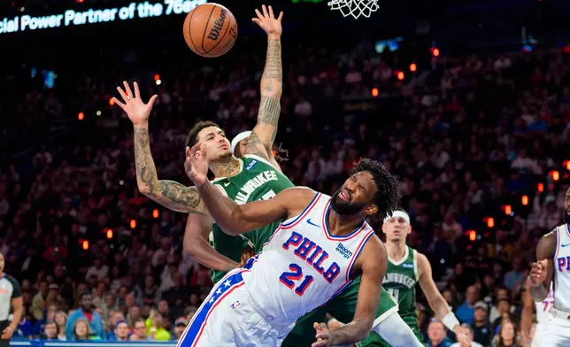 Philadelphia 76ers' Joel Embiid, right, reacts to being fouled by Milwaukee Bucks' Kyle Kuzma, left, as he went up for the shot during the first half of an NBA basketball game, Saturday, Oct. 24, 2026, in Philadelphia. (AP Photo/Chris Szagola)