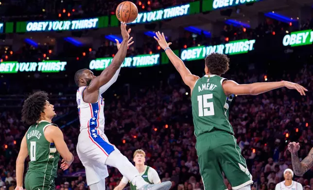 Philadelphia 76ers' Jaylen Brown, center, shoots the ball against Milwaukee Bucks' Nate Ament, right, during the first half of an NBA basketball game, Saturday, Oct. 24, 2026, in Philadelphia. (AP Photo/Chris Szagola)