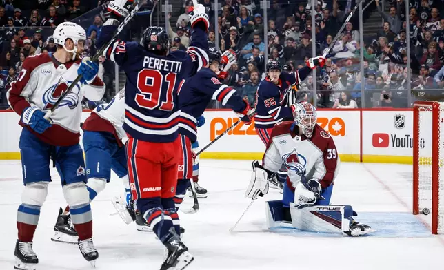Winnipeg Jets' Cole Perfetti (91) and Mark Scheifele (55) celebrate Kyle Connor's (81) goal on Colorado Avalanche goaltender Mackenzie Blackwood (39) during the second period of an NHL hockey game in Winnipeg, Wednesday, Oct. 7, 2026. (John Woods/The Canadian Press via AP)