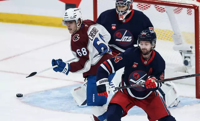 Winnipeg Jets' Josh Morrissey (44) defends against Colorado Avalanche's Zachary L'Heureux (68) during the first period of an NHL hockey game in Winnipeg, Wednesday, Oct. 7, 2026. (John Woods/The Canadian Press via AP)