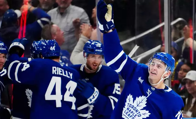 Toronto Maple Leafs' Troy Stecher, right, celebrates after his goal against the New York Rangers during the third period of an NHL hockey game in Toronto, Thursday, Oct. 22, 2026. (Frank Gunn/The Canadian Press via AP)