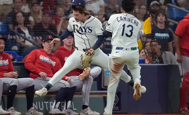 Tampa Bay Rays right fielder Jonny DeLuca and third baseman Junior Caminero collide try to catch a ball hit by Cleveland Guardians' Brayan Rocchio during the ninth inning in Game 1 of an American League Championship Series baseball game in St. Petersburg, Fla. Monday, Oct. 12, 2026. (AP Photo/David J. Phillip)