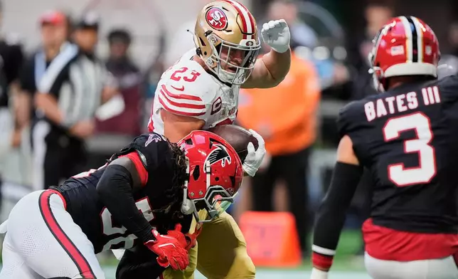 San Francisco 49ers running back Christian McCaffrey (23) carries the ball as Atlanta Falcons linebacker Harold Perkins Jr., bottom, makes the stop during the first half of an NFL football game in Atlanta, Sunday, Oct. 25, 2026. (AP Photo/Brynn Anderson)