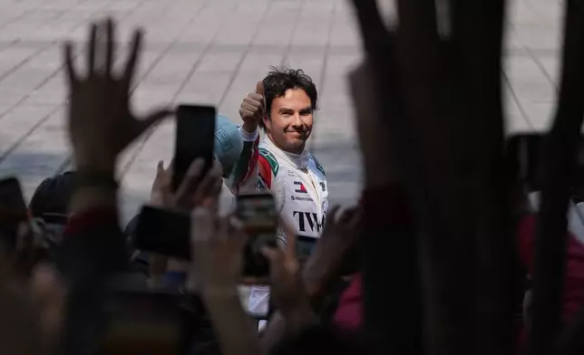Mexican driver Sergio Perez of the Cadillac F1 Team waves to the crowd during his exhibition drive along Paseo de la Reforma in Mexico City, Wednesday, Oct. 28, 2026. (AP Photo/Eduarto Verdugo)