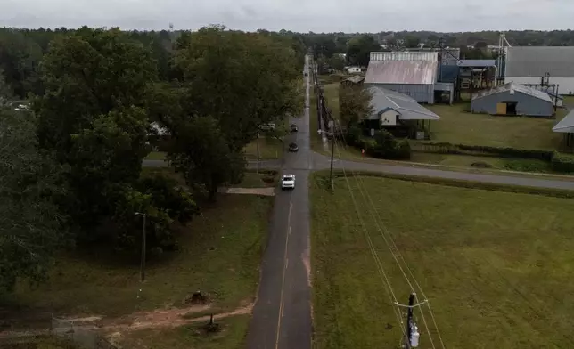A vehicle drives in the scene of a mass shooting where at least two people died and 35 were injured when struck by bullets Sunday morning, according to the Georgia Bureau of Investigation, Sunday, Oct. 4, 2026, in Vienna, Ga. (AP Photo/Mike Stewart)
