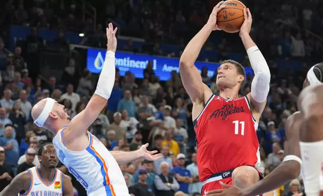 Los Angeles Clippers center Brook Lopez, right, shoots over Oklahoma City Thunder guard Alex Caruso during the second half of an NBA basketball game, Sunday, Oct. 25, 2026, in Oklahoma City. (AP Photo/Kyle Phillips)