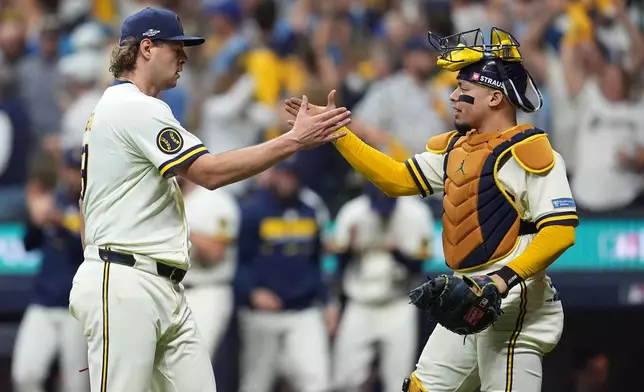 Milwaukee Brewers pitcher Trevor Megill, left, and catcher William Contreras celebrate after Game 1 of baseball's National League Championship Series between the Milwaukee Brewers and the Los Angeles Dodgers, Sunday, Oct. 11, 2026, in Milwaukee. (AP Photo/Abbie Parr)