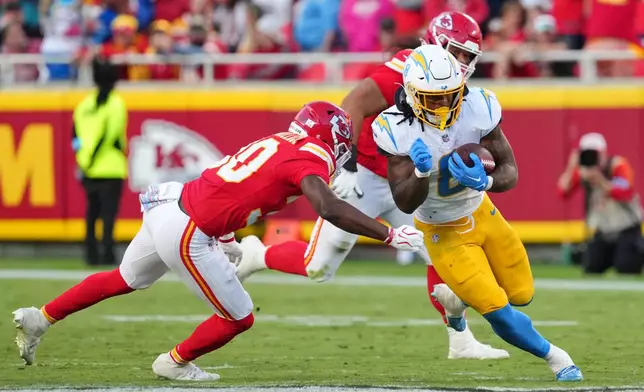 Los Angeles Chargers running back Omarion Hampton (8) gains yards after a catch as Kansas City Chiefs cornerback Chris Roland-Wallace, left, moves in to make the stop during the second half of an NFL football game in Kansas City, Mo., Sunday, Oct. 18, 2026. (AP Photo/Ed Zurga)