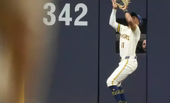 Milwaukee Brewers' Jackson Chourio catches a ball hit by San Diego Padres' Ty France after the ball hit a cable near the roof during the ninth inning in Game 1 of a National League Divisional baseball playoff series Sunday, Oct. 4, 2026, in Milwaukee. (AP Photo/Kayla Wolf)