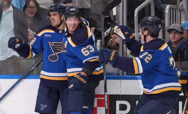 St. Louis Blues' Robert Thomas, left, is congratulated by teammates Jake Neighbours (63) and Justin Barron (72) after scoring during the second period of an NHL hockey game against the Boston Bruins Thursday, Oct. 29, 2026, in St. Louis. (AP Photo/Jeff Roberson)