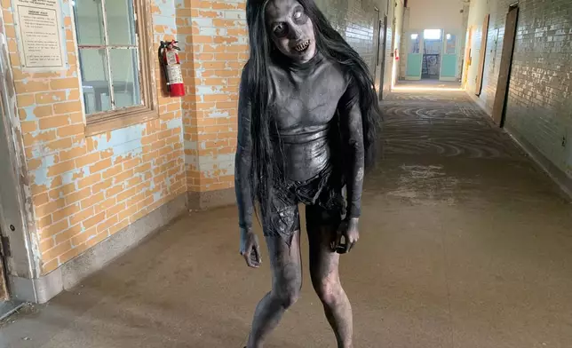Lexi Carter, the lead makeup artist and a scare actor at Eloise Asylum, stands in the hallway on an upper floor at Eloise Asylum that treated patients when the building was a psychiatric hospital, Thursday, Sept. 24, 2026, in Westland, Mich. (AP Photo/Mike Householder)